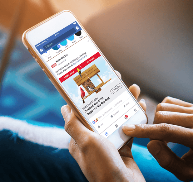 hand holding mobile device open to facebook showing an ad